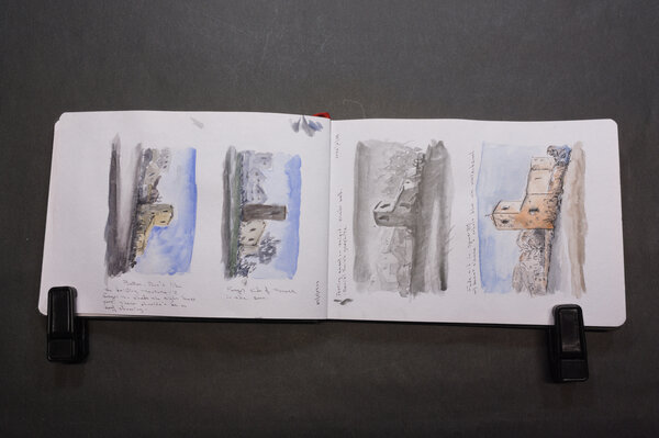 Four attempts at a watercolor of an old mission style building with a tower and rounded corner end, with a back drop of poor neighborhood buildings.